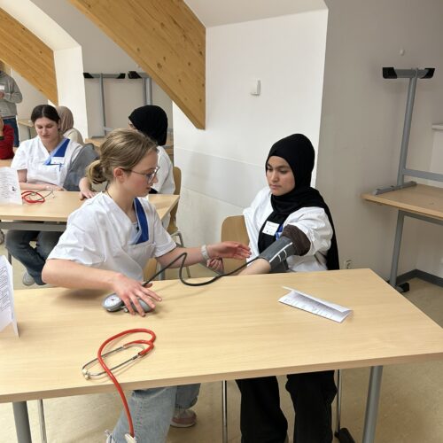 Zwei Schülerinnen die sich gegenseitig den Blutdruck messen